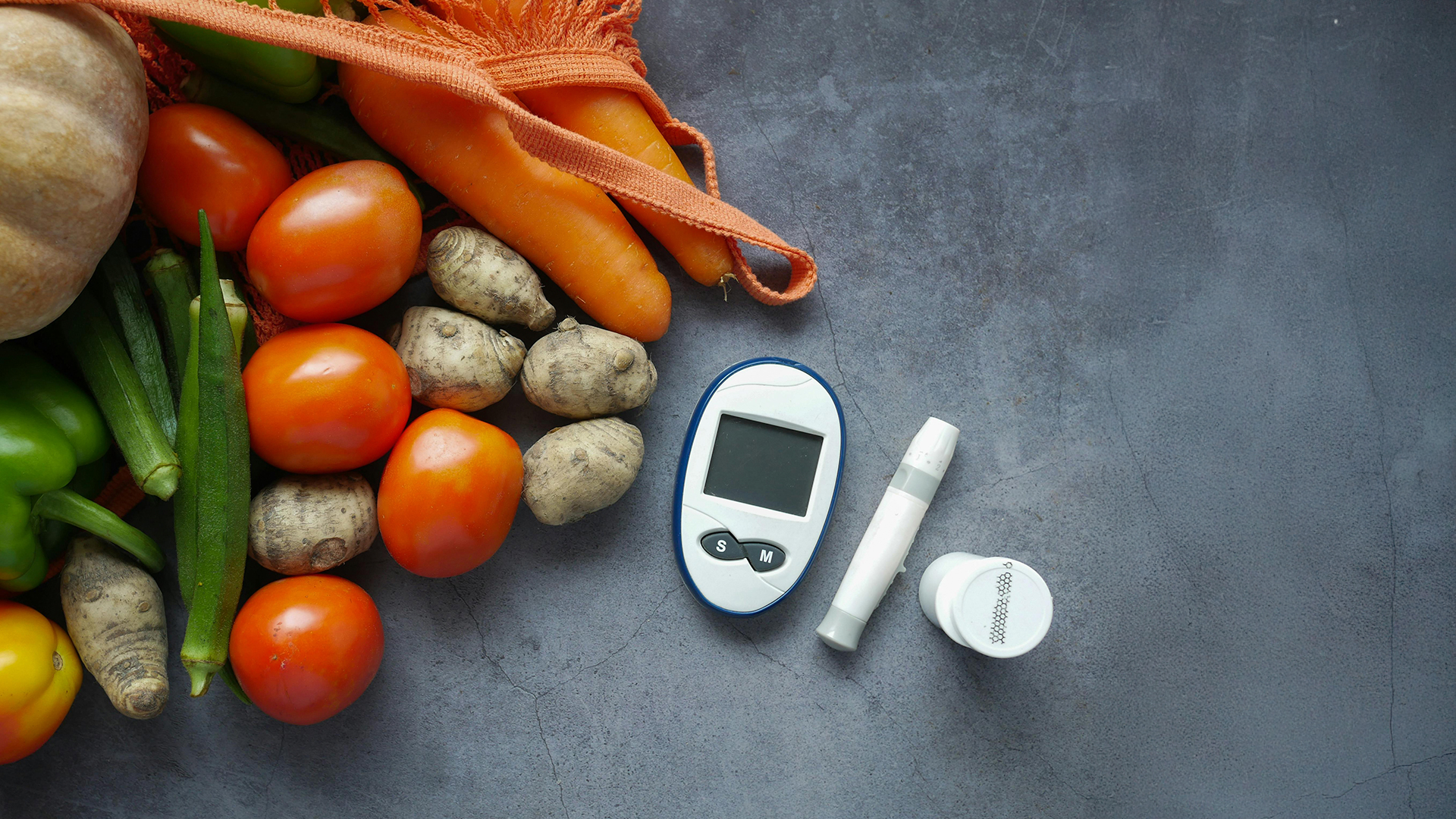 Blood sugar monitor and diabetic testing supplies next to fresh fruits, vegetables, and whole grains, symbolizing holistic blood sugar management.