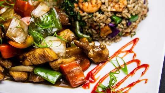 Colorful stir-fry with vegetables, chicken, and a side of brown rice with shrimp—high-energy food that supports stable blood sugar.
